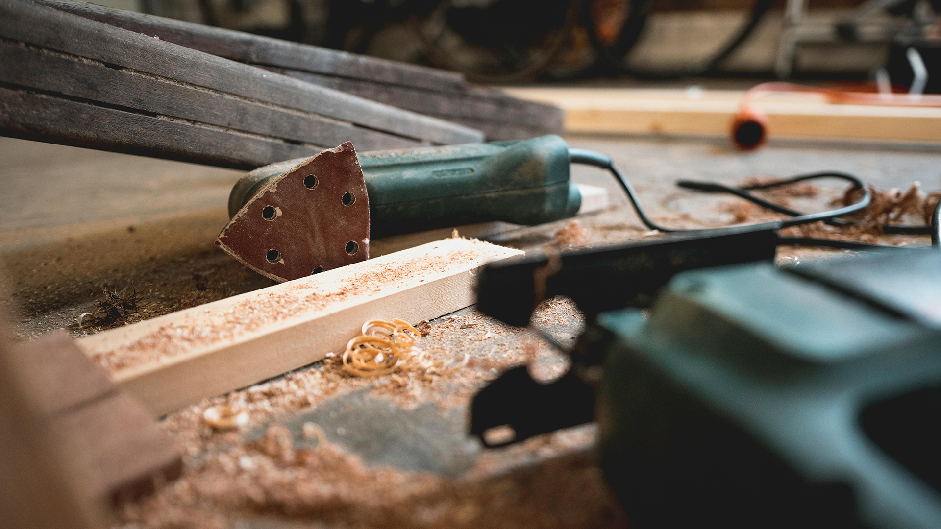 Carpentry tools and wood lying on floor.