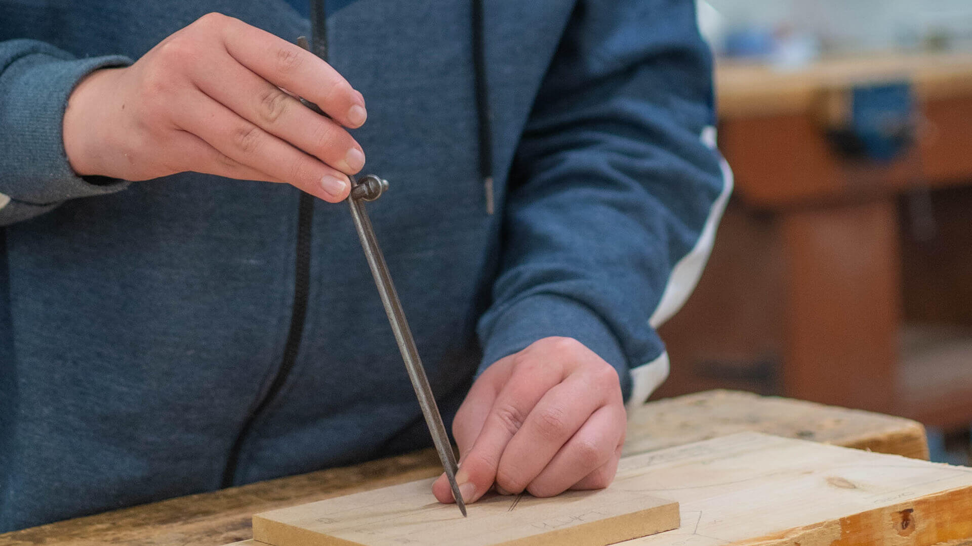 A close up of someone using a tool on a piece of wood.
