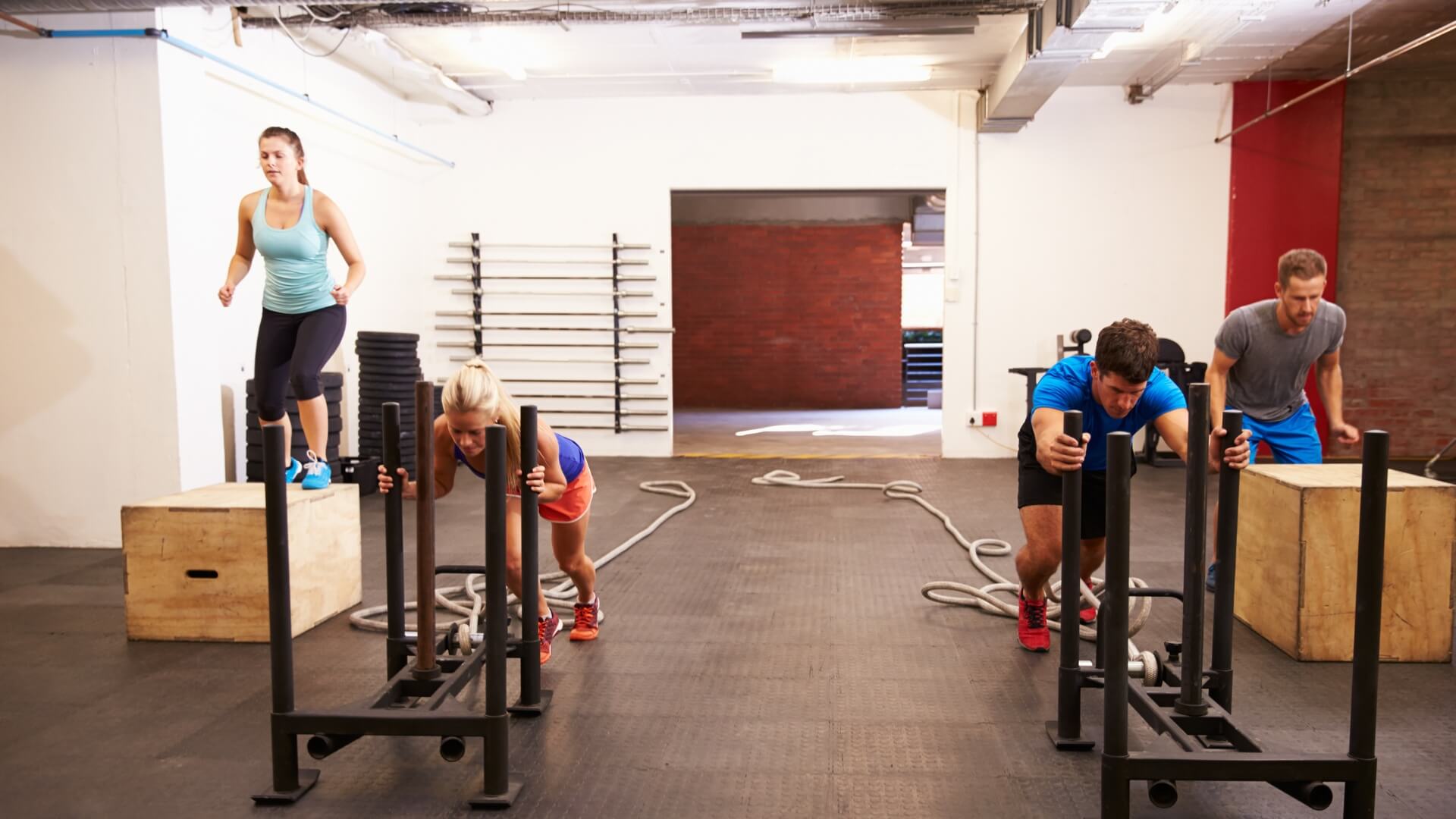 A row of people using kettlebells in a gym class.