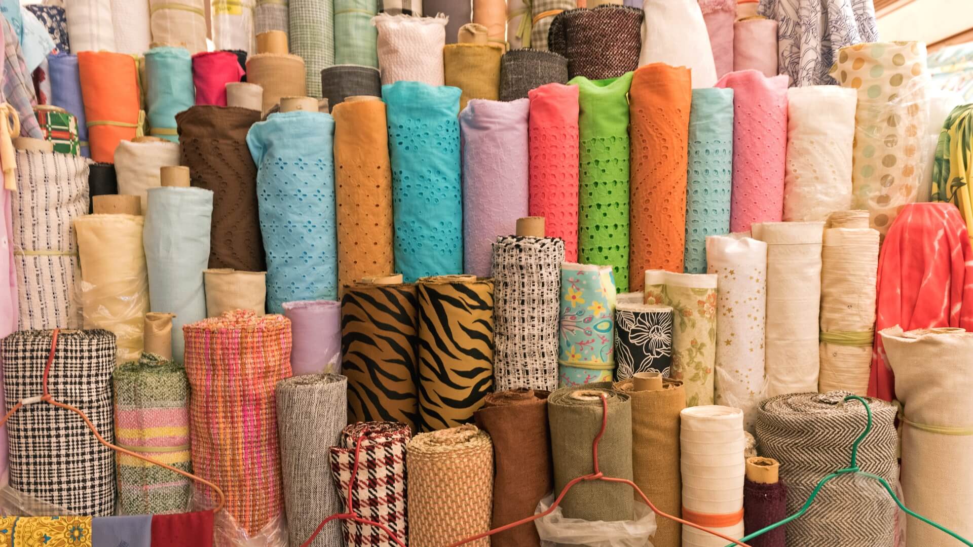 Table full of thread, buttons, a measuring tape and a thimble.