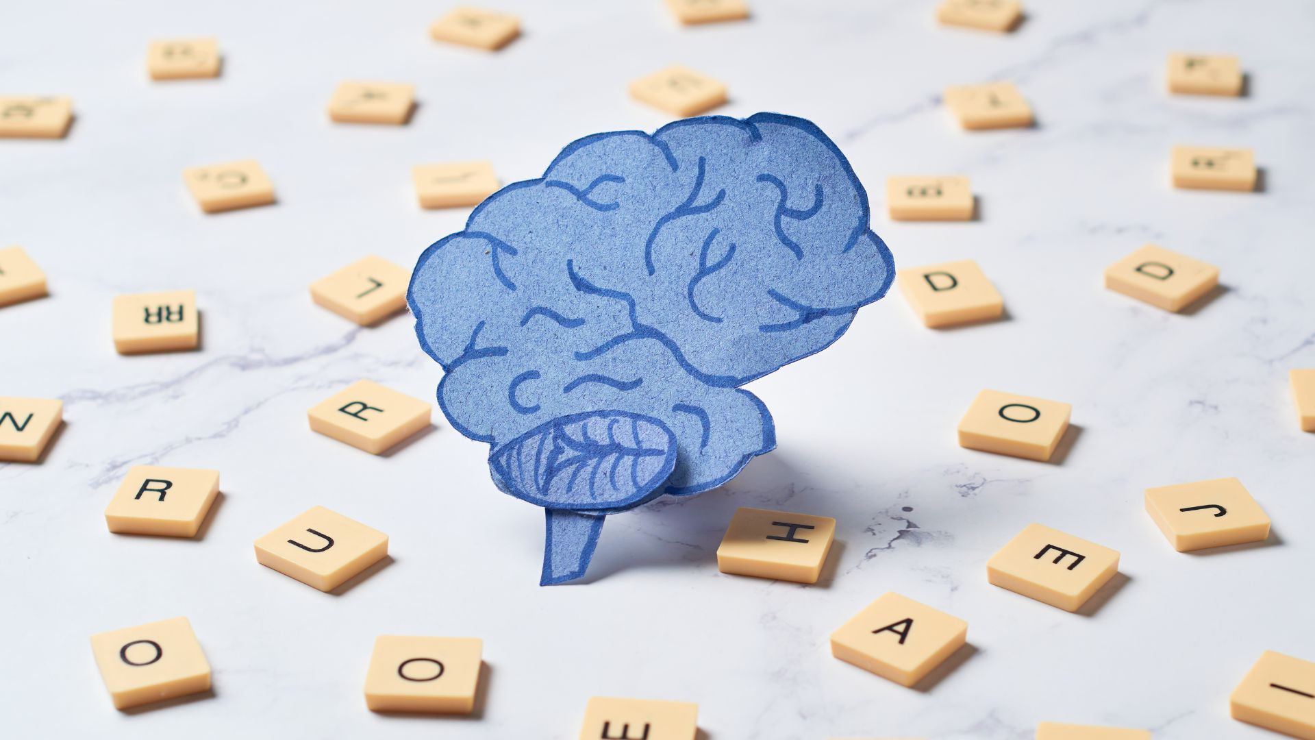 Blue brain graphic surrounded by wooden tiles showing letters