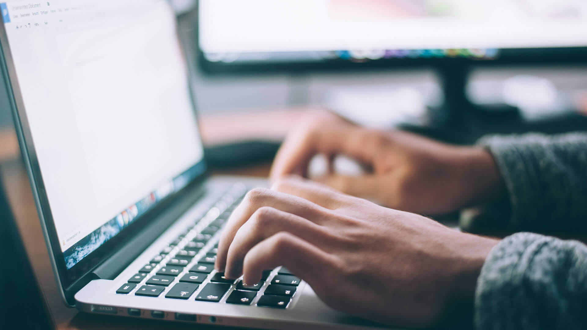 Close up of someones hands typing on laptop.