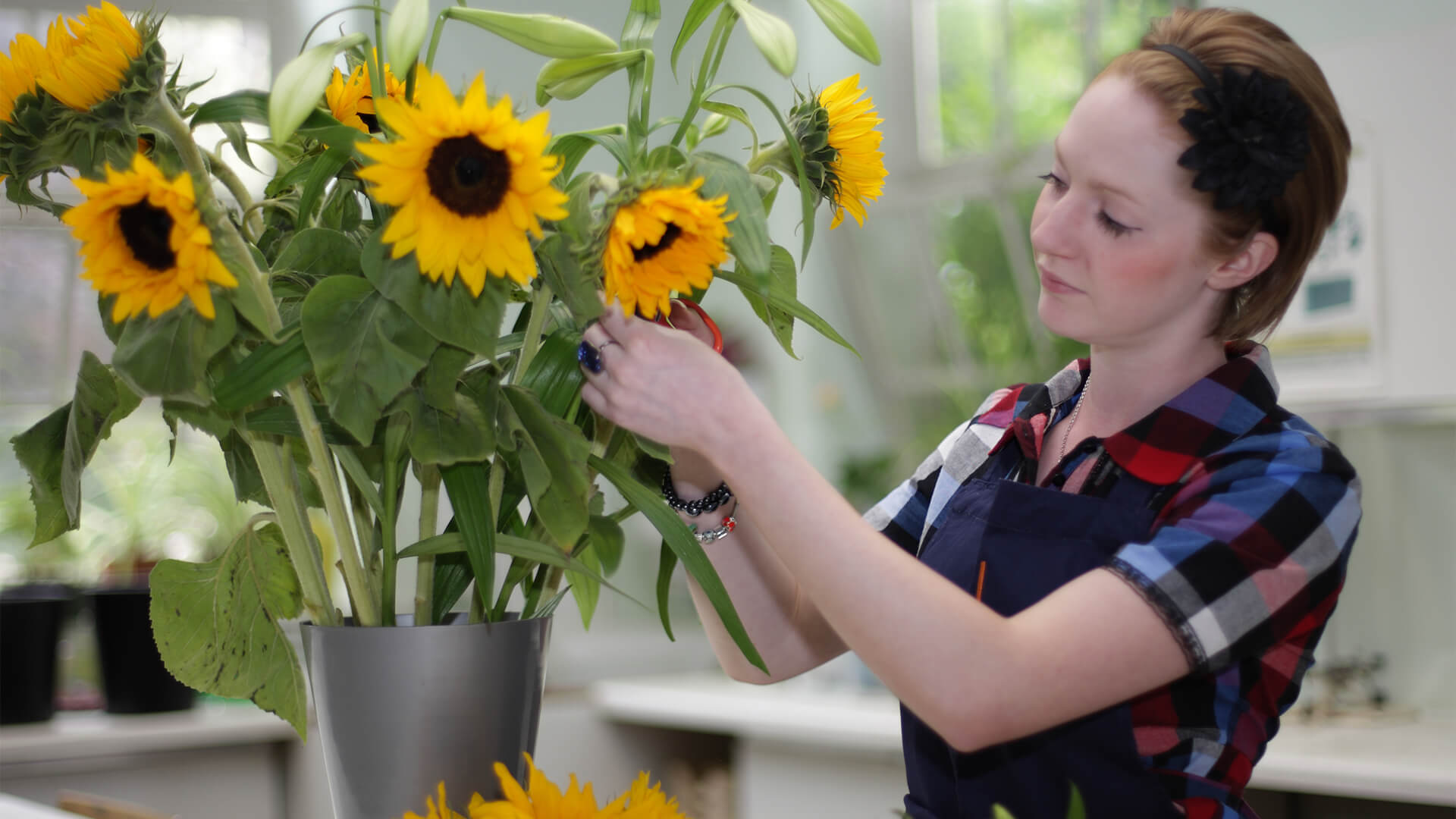 Young woman arranging a bouquet of sunflowers.