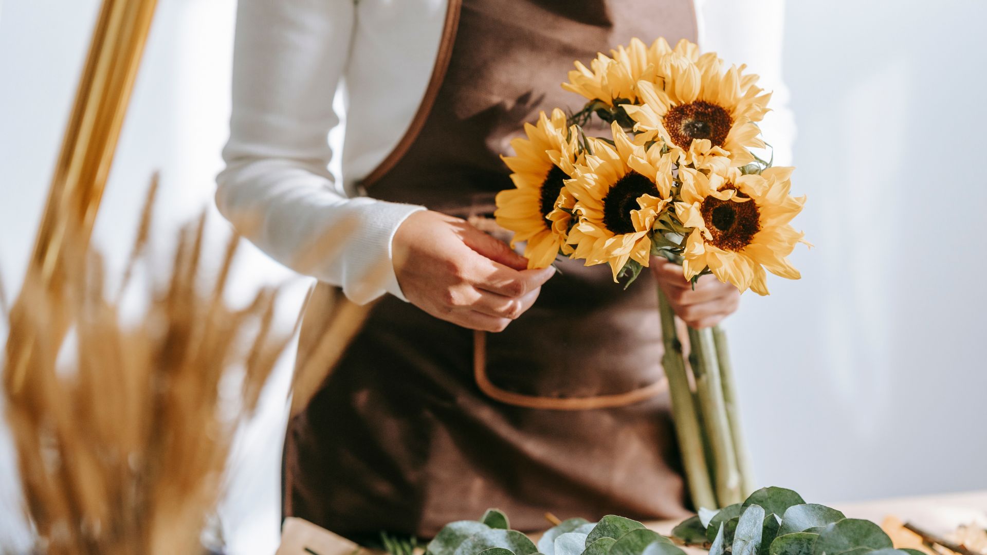 Young woman arranging a bouquet of sunflowers.
