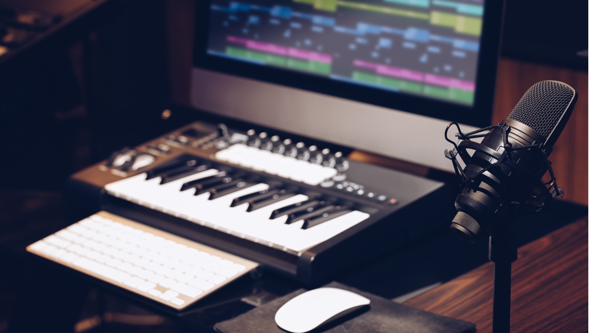 Microphone, midi keyboard and monitor in recording studio