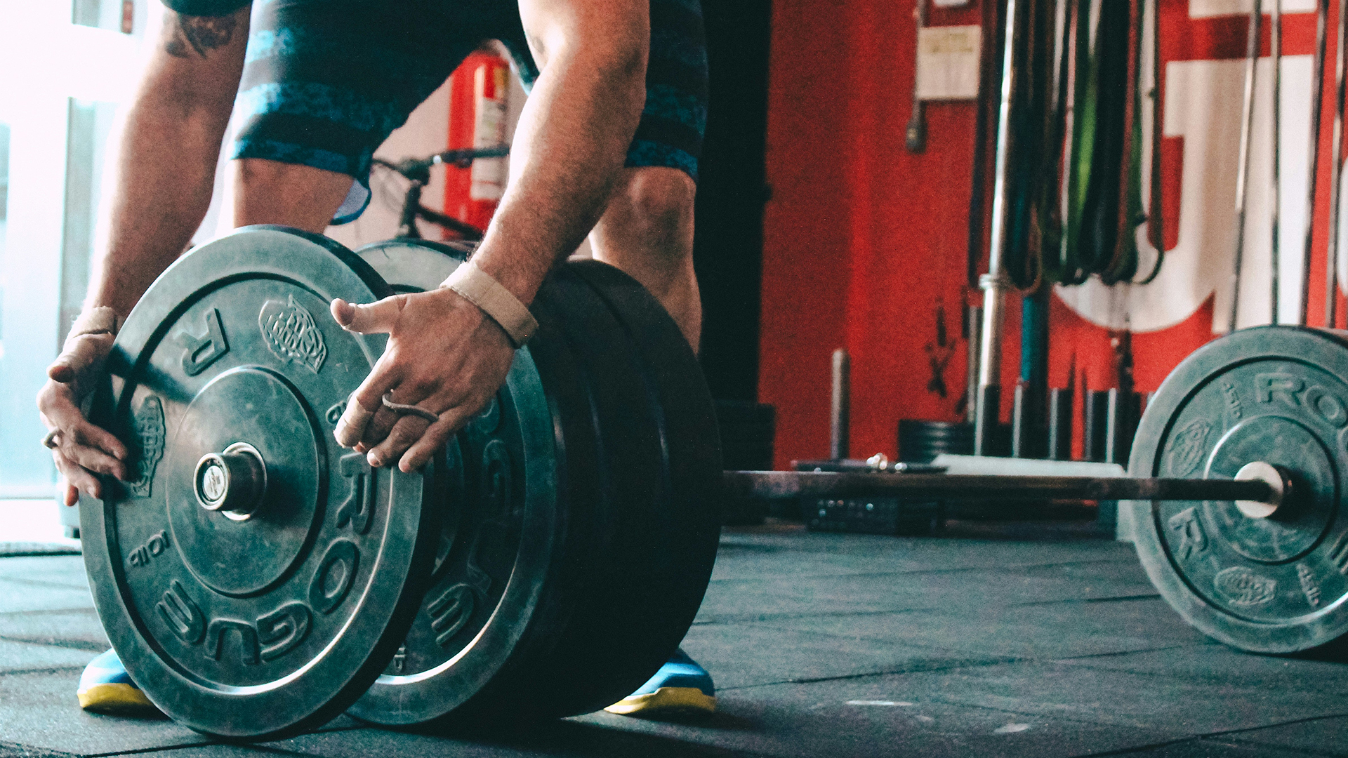 Man putting weights onto barbell in gym