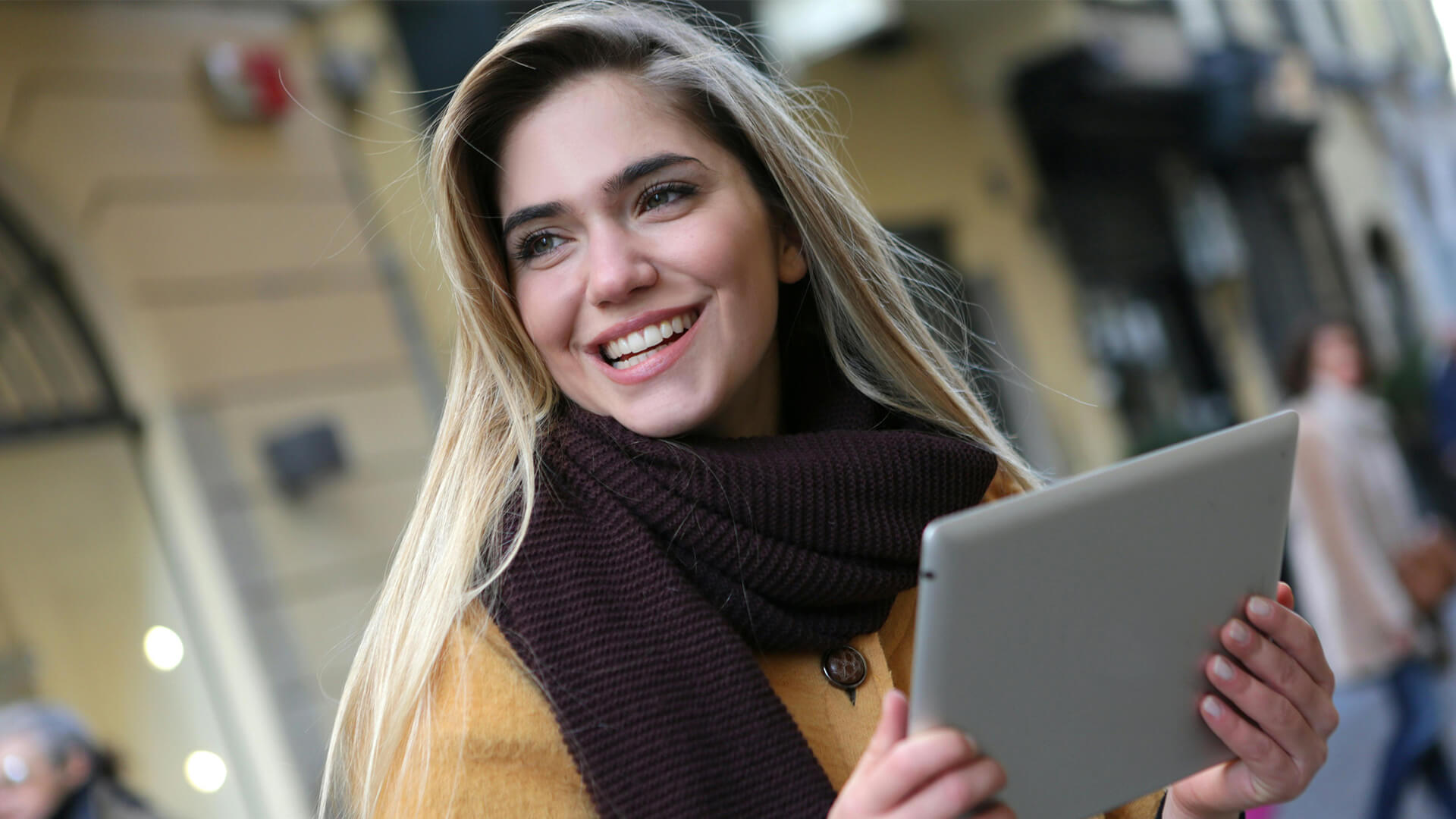 Two young women at a computer, having a conversation and smiling.