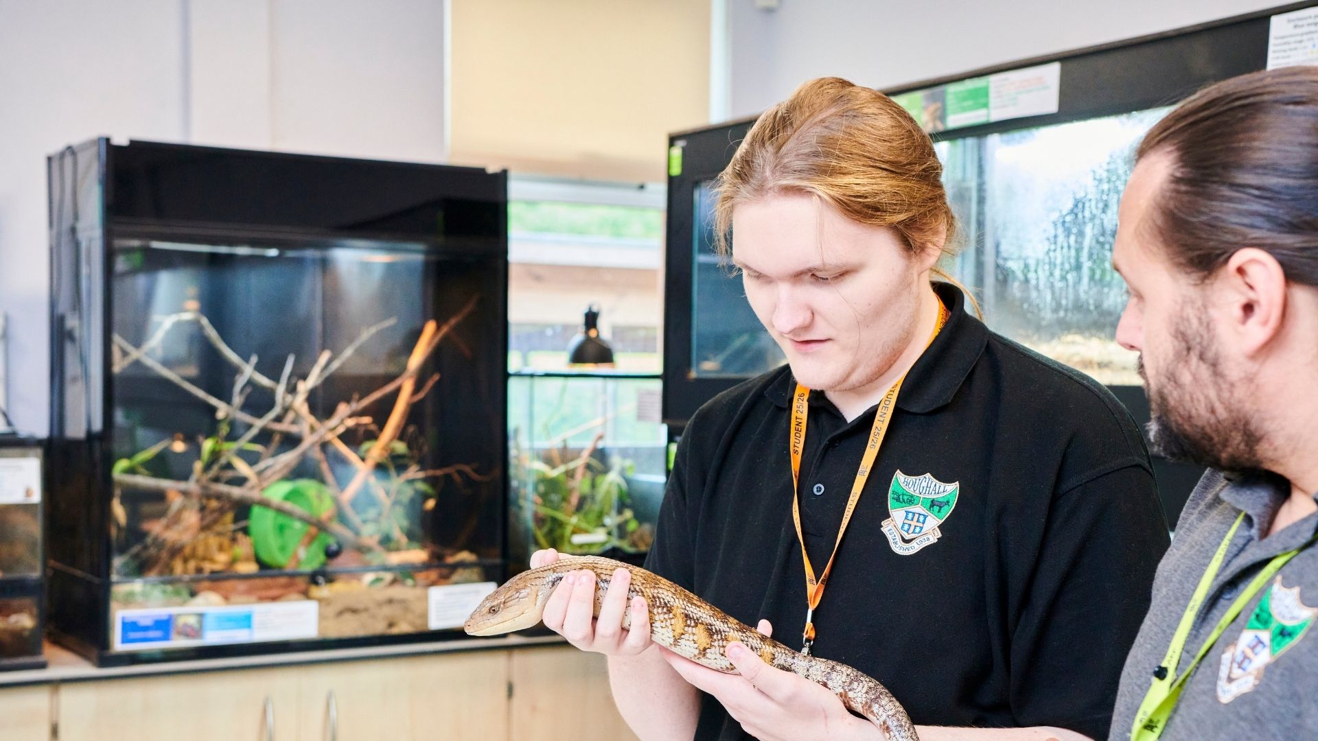 A student holding a small reptile