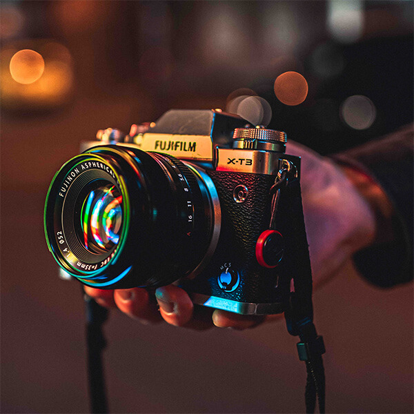 A hand holding a professional lens camera.