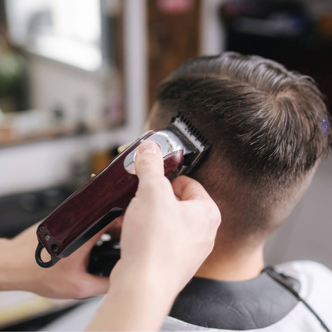 Barbering student performing a fade with an electric razor