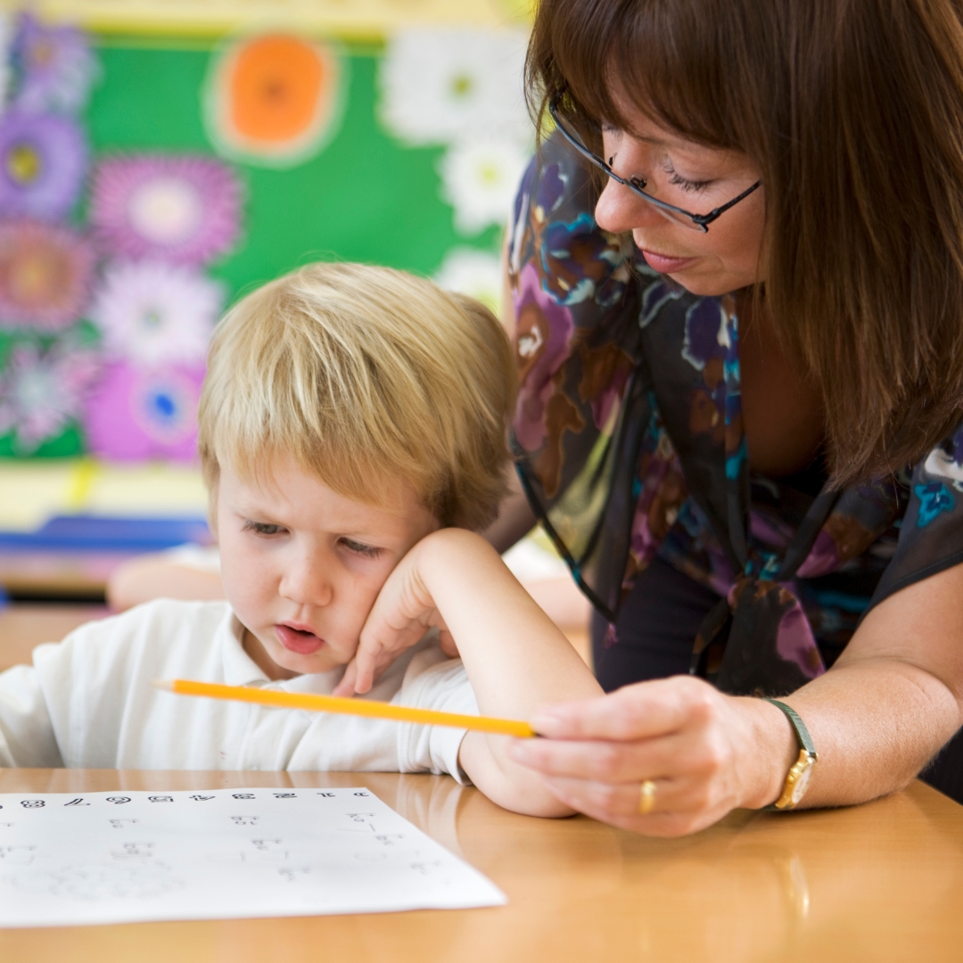 Teacher working with student in class.