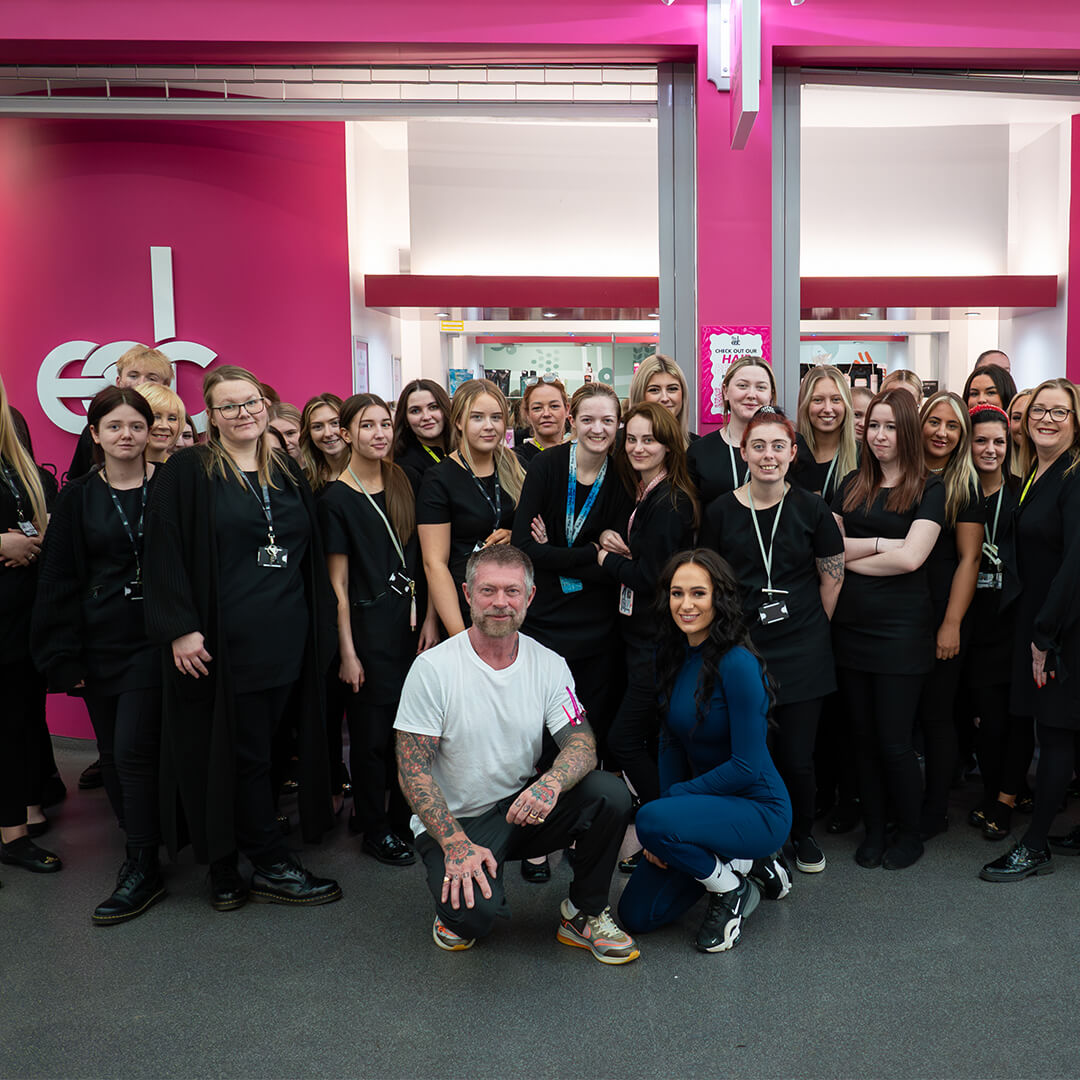Celebrity hair stylist, Lee Stafford, curling a blonde woman's hair whilst in East Durham College's hair salon.