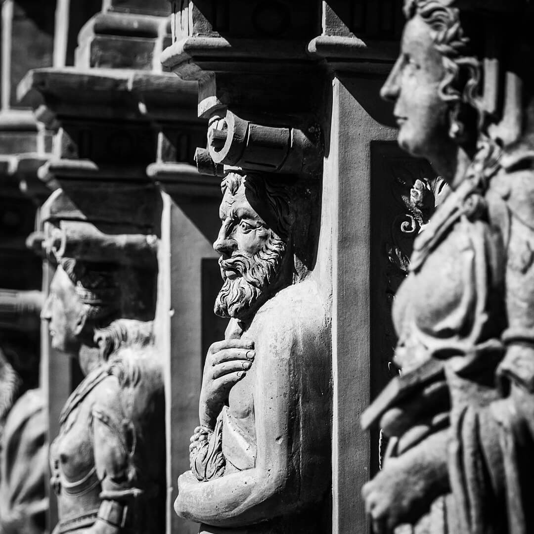 Row of human statue busts of historical men.