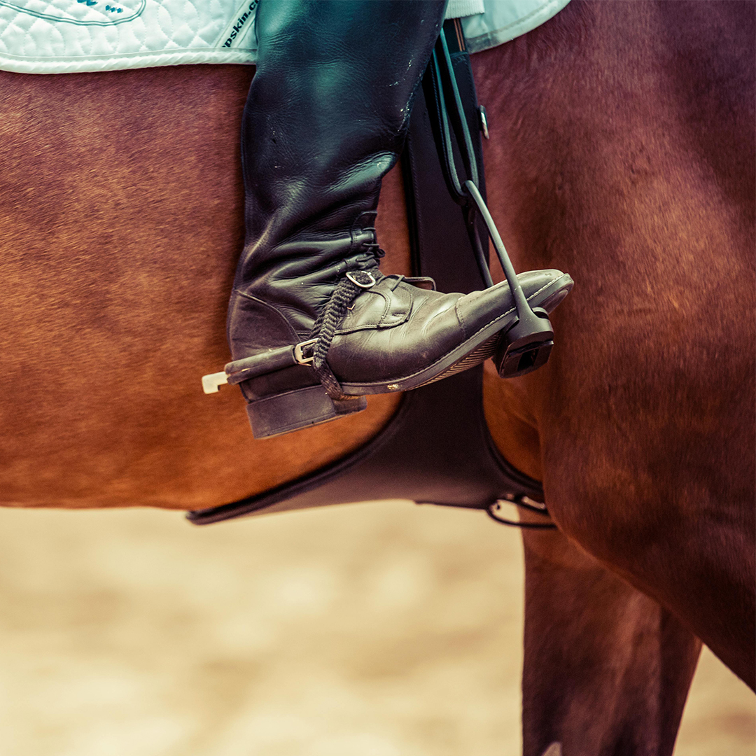 Close up of horse riders boots in stirrups.