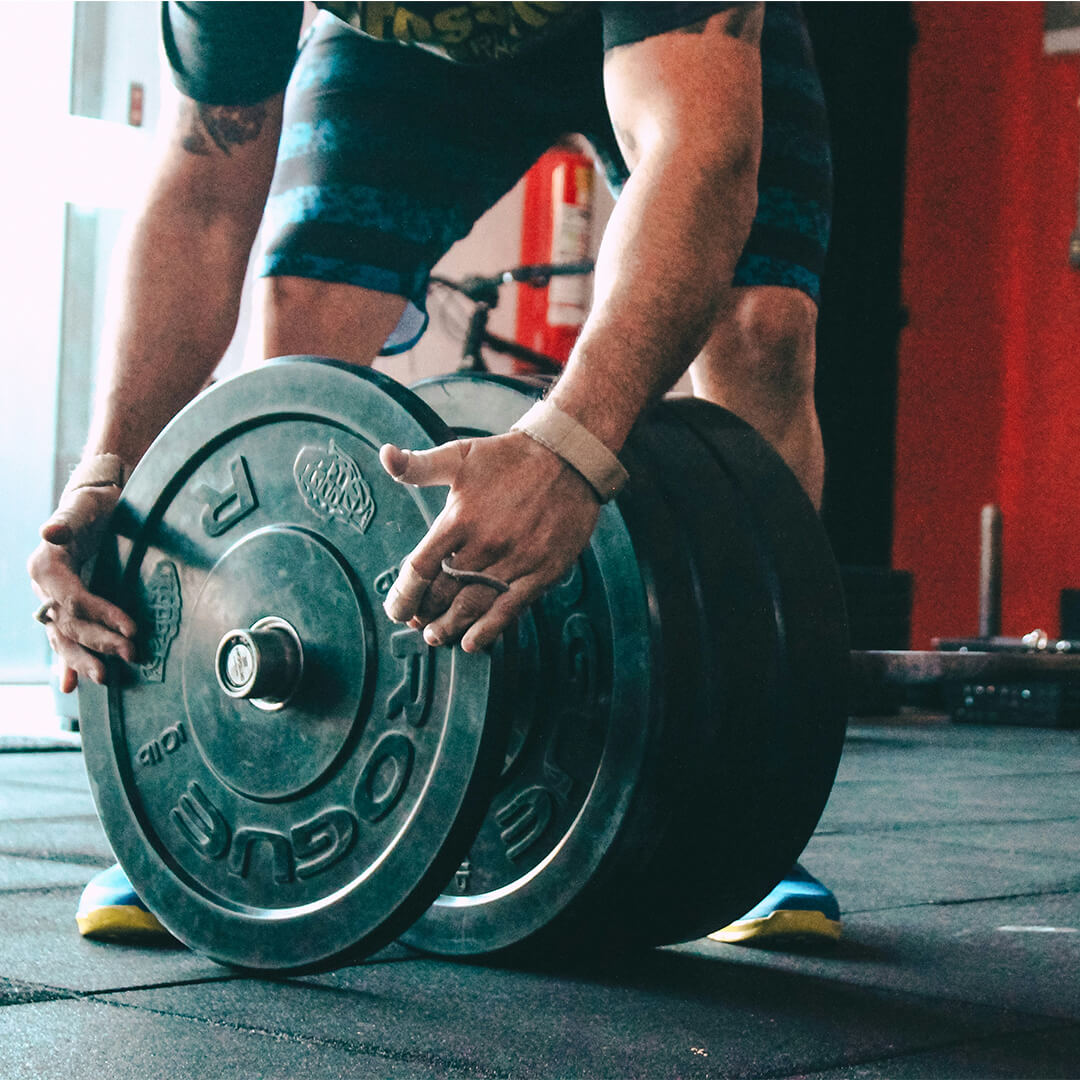 Man putting weights onto barbell in gym