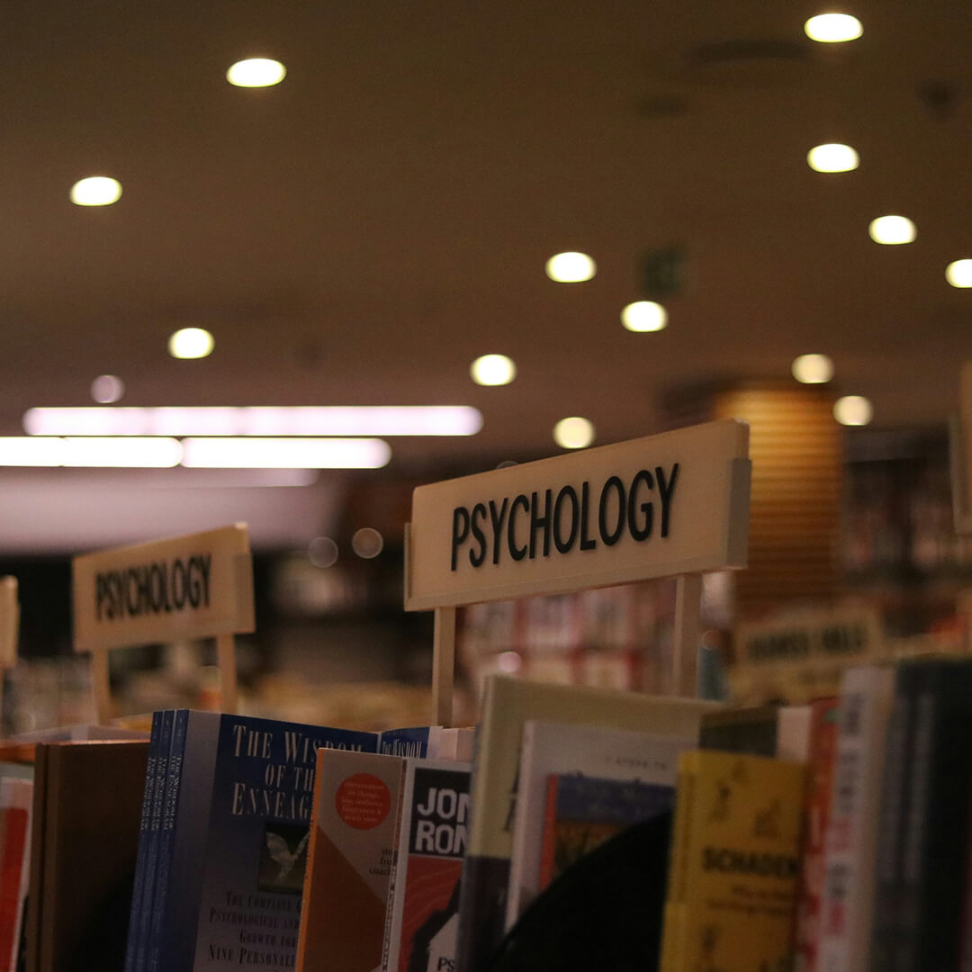 Young woman sat in the library reading a book.