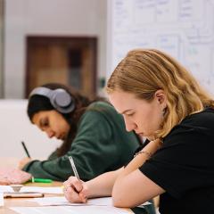 Two students writing on desk