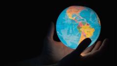 Hands holding a globe with black background