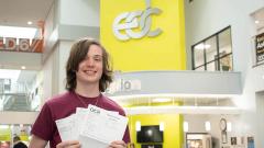 Photo of Callum Watson holding exam certificates