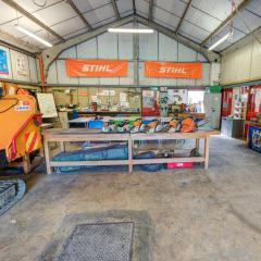 Tree surgery workshop showing a bench with chainsaws and large wood chipping machine at the Houghall Campus