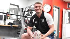 Jake Rodgers holding rugby ball in gym
