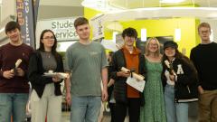 ED6 Students holding results and smiling at camera