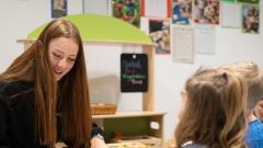 Student smiling and laughing with two children