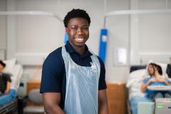 Smiling student in front of hospital ward beds