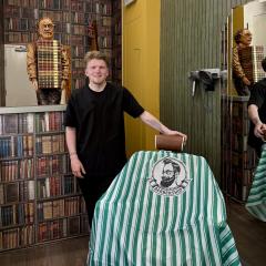 Young male standing in barbershop next to chair