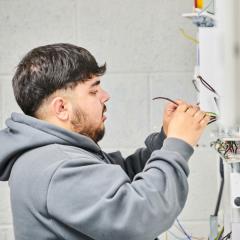 Electrical student inspecting wires