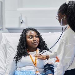One student using stethoscope on other student