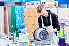 Student cleaning paint bucket