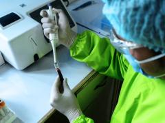 Person holding machine up to test tube